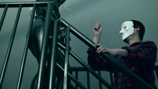 chinese latex woman solider being taken down the stairs with a chain